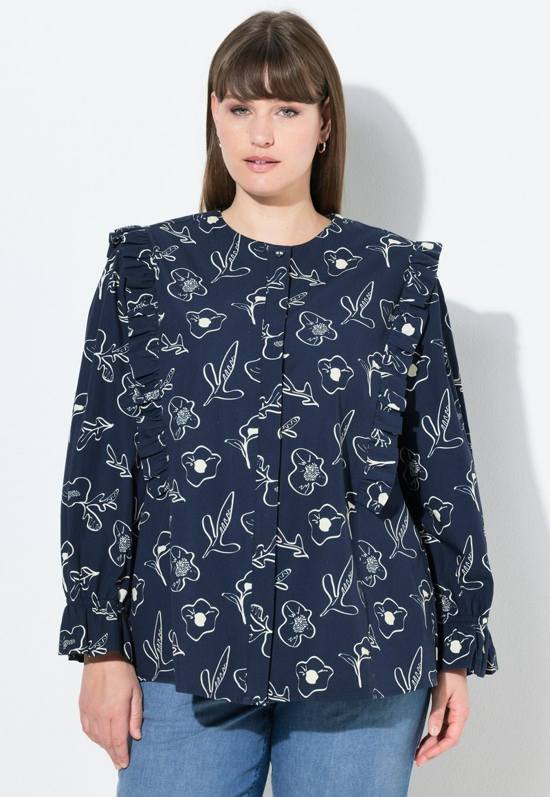 Blusa navy con stampa floreale, caratterizzata da spalle arricciate, chiusura frontale con bottoni e maniche lunghe. Realizzata in tessuto leggero.