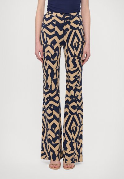Pantalones acampanados de patrón navy y beige con diseño geométrico, que presentan una textura suave y una cintura alta con bolsillos laterales.