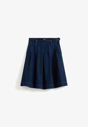 Donkerblauwe denim rok met een uitlopende vorm, plooien ter hoogte van de taille en contrasterende stiksels langs de zoom en tailleband. Voorzien van riemlussen.