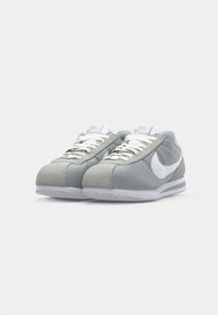 Gray and light teal suede sneakers with white laces and Nike logo. Rounded toe and textured outsole with white detailing.