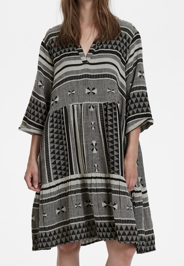 Grau gemustertes Kleid mit V-Ausschnitt, kurzen Ärmeln und lockerer Passform. Verfügt über geometrische Designs und strukturierte Stoffe.