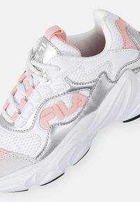 Sneaker atletica bianca con dettagli argento e rosa, caratterizzata da una tomaia in rete, chiusura con lacci e suola testurizzata. Logo Fila sul lato.