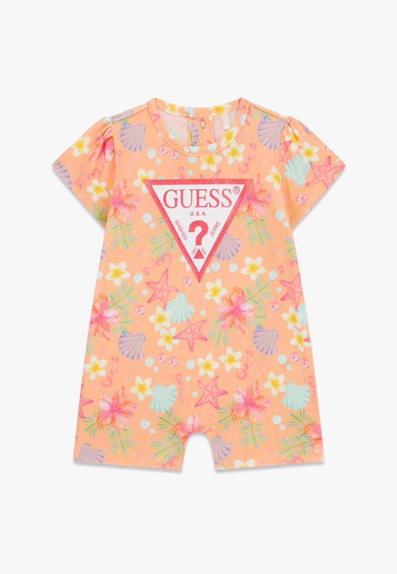 Barboteuse pour bébé couleur pêche avec motifs floraux tropicaux et coquillages, arborant un grand triangle rouge avec le logo GUESS sur le devant.