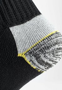 Calzino nero con tallone rinforzato in grigio e accenti gialli. Texture lavorata a maglia, con un design a pattern nella zona del tallone.