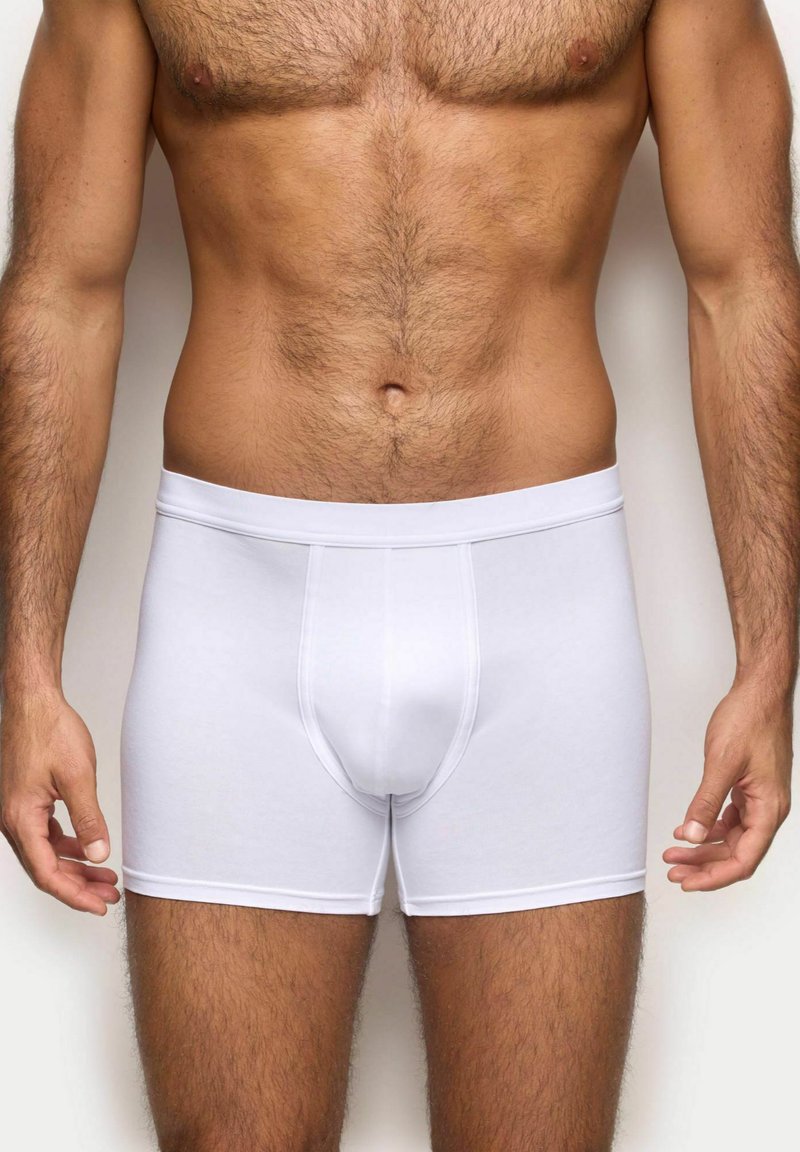 Boxer bianchi realizzati in tessuto elasticizzato, con un morbido elastico in vita e una vestibilità aderente. Texture liscia con dettagli di cucitura minimi.