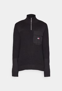 Schwarzer Strickpullover mit hohem Kragen und einem viertel Reißverschluss; verfügt über eine frontale Tasche sowie gerippte Bündchen und Saum. Texturierter Stoff mit unterschiedlichen Mustern.
