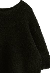 Musta, pörröinen neulepaita pyöreällä pääntiellä ja rennolla istuvuudella. Pehmeä tekstuuri, paksu ja kodikas ilme ilman näkyviä varusteita tai kuvioita.