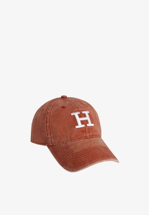 Rustfarvet baseballkasket med hvid broderet "H" logo, blødt stof, buet skygge og justerbar rem bagpå.