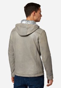 Lichtgrijze leren jas met capuchon, voorzien van een soepele textuur, getailleerde pasvorm en contrasterende zilveren voering. Eenvoudige stikdetails.