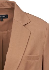Brown blazer made of textured fabric, featuring a notched lapel, open pocket, and straight cut. Size tag visible inside.