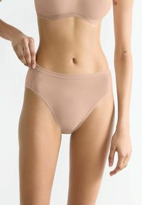Nude nahtlose Slips mit glatter Textur, hohen Beinausschnitten und einem bequemen Bund. Besitzt ein minimalistisches Design.