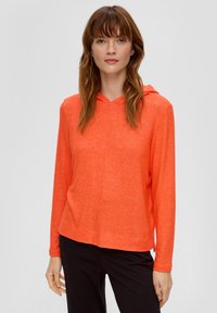 Hoodie in feloranje textuurstof, met lange mouwen en een relaxte pasvorm, gecombineerd met zwarte broek.