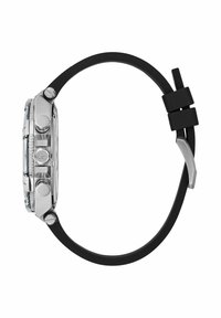 Montre chronographe argentée avec boutons latéraux et bracelet en caoutchouc noir, vue de profil sur fond blanc.