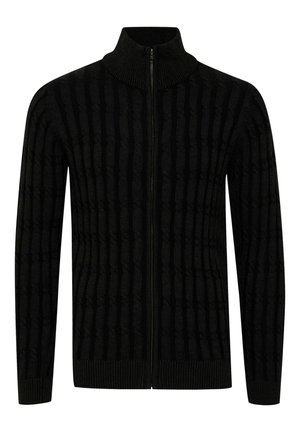 Svart glidelås-genser med ribbet tekstur og vertikale striper. Har høy krage og tettsittende ermer. Laget av mykt, vevd materiale.