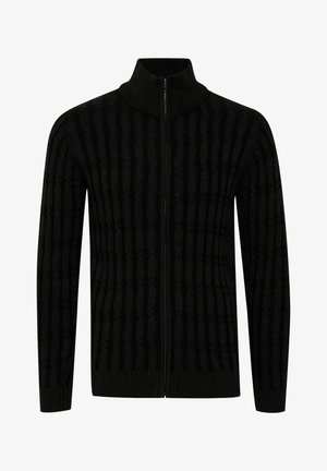 Cardigan noir zippé avec texture côtelée et rayures verticales. Il possède un col montant et des poignets ajustés. Fabriqué en matériau tissé doux.