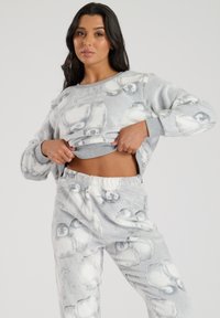 Set di pigiama grigio fuzzy con illustrazioni di pinguini, composto da una maglietta con scollo tondo e pantaloni con vita elasticizzata per una vestibilità comoda.