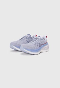 Baskets de sport gris clair avec un dessus en maille texturée, accents bleus et semelle rembourrée. Présente des lacets et une boucle au talon en rouge.