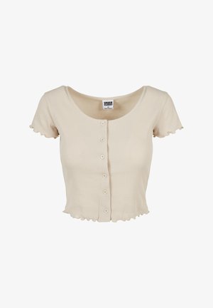 Beige, ribbet kortærmet top med rund halsudskæring, flæsedetaljer i kanten og ærmerne, fem knapper foran og et tætsiddende design.