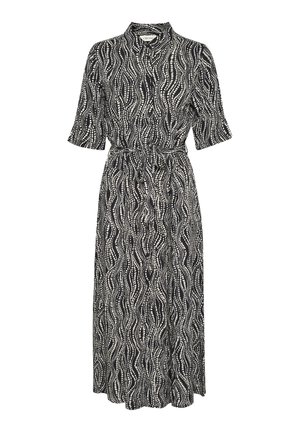 Haljina crne i bijele boje s uzorkom valova, ovratnikom, kratkim rukavima i vezanom strukom. Tkanina izgleda lagano s glatkom teksturom.