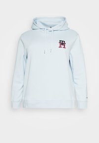 Sudadera azul clara hecha de una mezcla de algodón, que cuenta con un bolsillo frontal, cordones y un logo bordado en rojo y negro en el lado izquierdo del pecho.