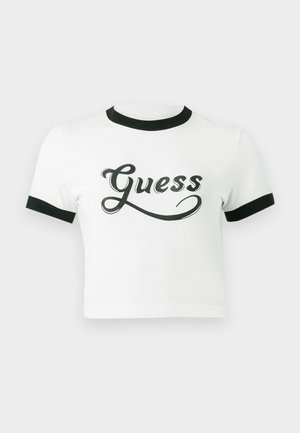 Hvid cropped t-shirt med sort ribbet krave og ærmekanter. Har "Guess" logo i fed sort skrift på forsiden. Glat tekstur.