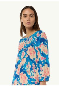 Flieder Kleid in Blau-, Pink- und Creme-Tönen. Mit Dreiviertelärmeln, runder Halslinie und einer weichen, glatten Textur in lässiger Passform.