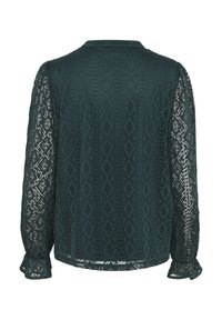 Blusa verde scuro con un tessuto testurizzato e a fantasia, maniche lunghe in pizzo e colletto rotondo. L'orlo è dritto con polsini arricciati.