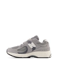 Chaussure de sport grise avec des matériaux en mesh et en daim, dotée d'un logo blanc, d'un dessus texturé et d'une épaisse semelle intermédiaire blanche avec une semelle extérieure noire.