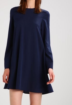 Robe bleu marine à manches longues avec un col rond, silhouette évasée, texture lisse et design minimaliste. Longueur au-dessus du genou.