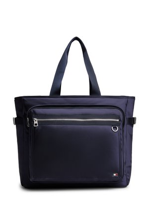 Borsa tote blu navy con due manici, tasca frontale con zip, dettagli con fibbia ai lati e un piccolo logo rettangolare nell'angolo in basso a destra.