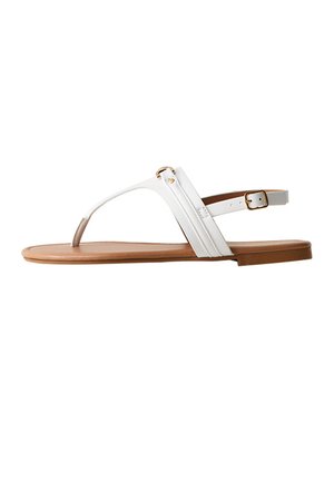 Sandalo bianco piatto con design a cinturino a infradito, chiusura con fibbia alla caviglia e suola color cuoio, mostrato di profilo su sfondo bianco.