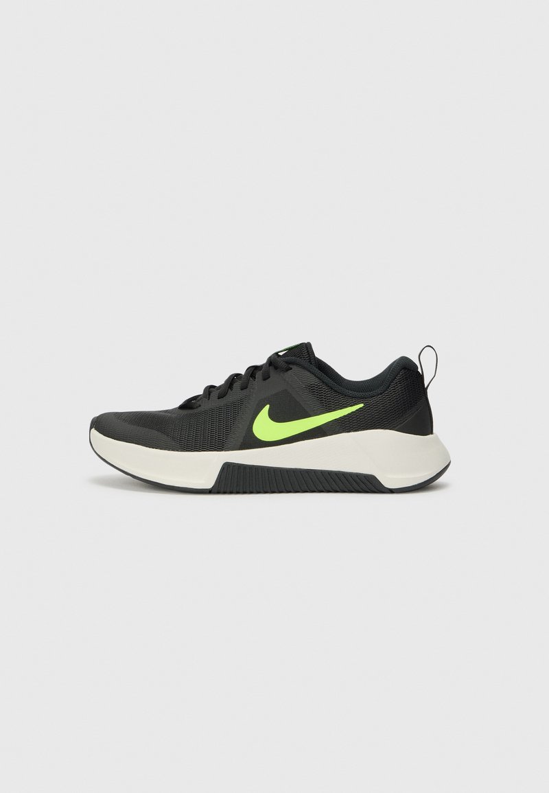 Sorte atletisk sko med en tekstureret mesh-overdel, neongrøn Nike-logo, hvid mellemsål og en gummiydersål. Har en hæltrækstrop.