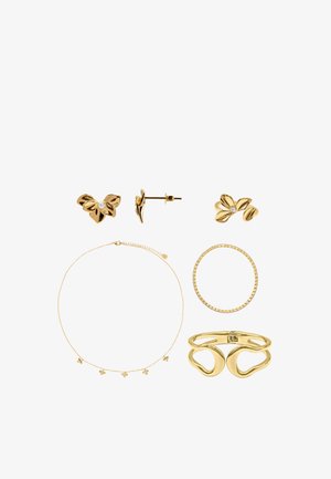 Boucles d'oreilles clous florales en or, un collier fin en or avec petits charms, une bague en or, un bracelet circulaire en or et un bracelet manchette en or de forme abstraite.