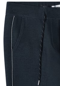 Joggers bleu foncé en tissu texturé, avec une ceinture élastique, des poches latérales et des coutures blanches contrastantes le long des poches.