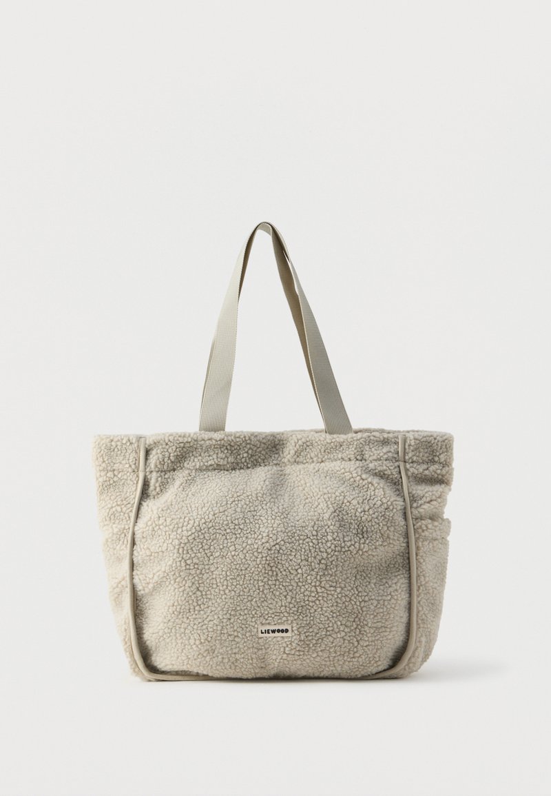Torba tote w kremowym polarze z jasnoszarymi ramiączkami. Charakteryzuje się miękką fakturą, marszczonym brzegiem oraz widocznym logo z przodu.