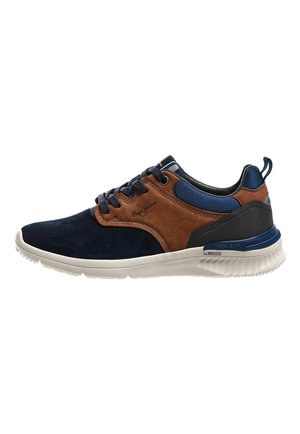 Zapatilla casual de hombre en azul marino, marrón y negro con suela blanca, diseño de cordones y detalles de marca en el lateral.