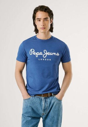 Camiseta de algodón azul con el logo en cursiva blanco "Pepe Jeans" y el texto "LONDON", cuello redondo y mangas cortas, combinada con unos jeans de color azul claro.