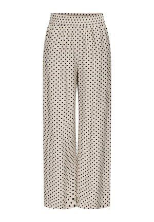 Pantalon beige à jambes larges avec une taille élastique, présentant un motif à pois noirs uniformément réparti sur le tissu.