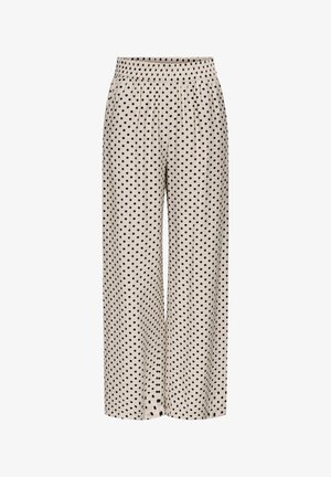 Pantalon beige à jambes larges avec une taille élastique, présentant un motif à pois noirs uniformément réparti sur le tissu.