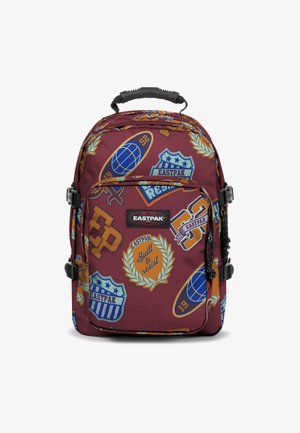 Mochila color burdeos con varios parches coloridos, que presentan formas redondas, íconos deportivos y el texto "Construida para resistir", acentuada con herrajes negros.