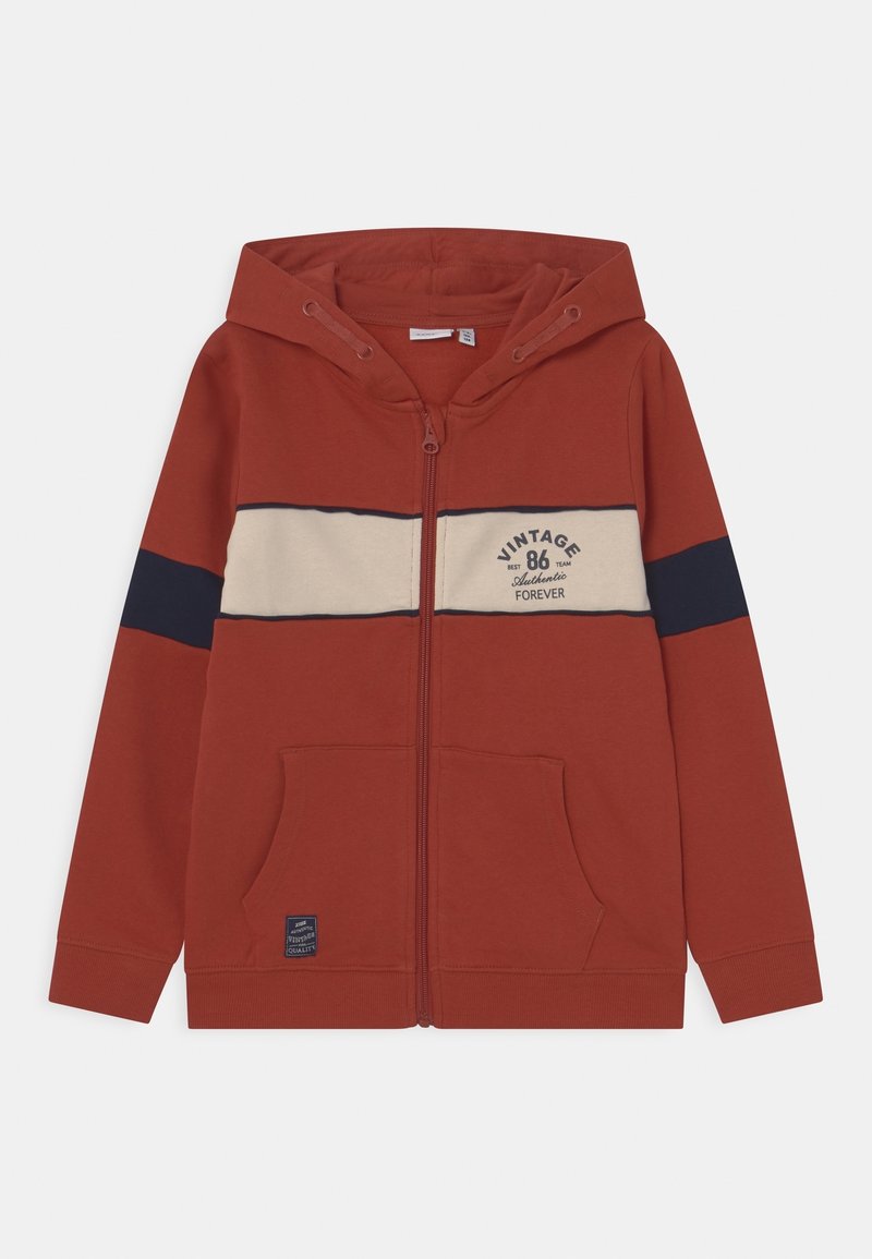 Sweat à capuche zippé couleur bordeaux avec un design rayé crème et marine sur la poitrine ; doté d'une poche avant et d'une capuche à cordon ajustable.