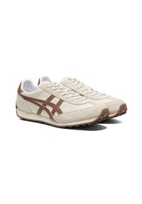 Beżowe i brązowe niskie sneakersy z zapięciem na sznurówki oraz teksturowanymi podeszwami, pokazane w parze skierowanej w prawo na białym tle.