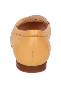 Leder-Schlupfschuh in sanftem Gelb, runde Form, glatte Textur, mit einer braunen Gummisohle und dezenten Nähten entlang der Rückseite.
