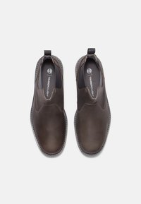 Hnědé kožené slip-on boty s kulatou špičkou, elastickými bočními panely a odolnou podrážkou. Disponují kontrastním šitím a logem na stélce.