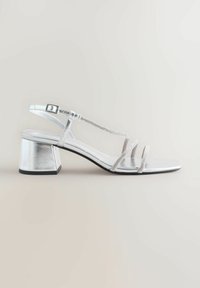 Silberne Sandalen mit Blockabsatz, die ein elegantes Design aufweisen, mehrere dünne Riemen haben und mit Strasssteinen entlang der Riemen akzentuiert sind.