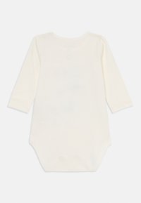 Långärmad babybodysuit i mjuk krämfärgad bomull, med rundad halsringning och tryckknappar bak för enkel påklädning.