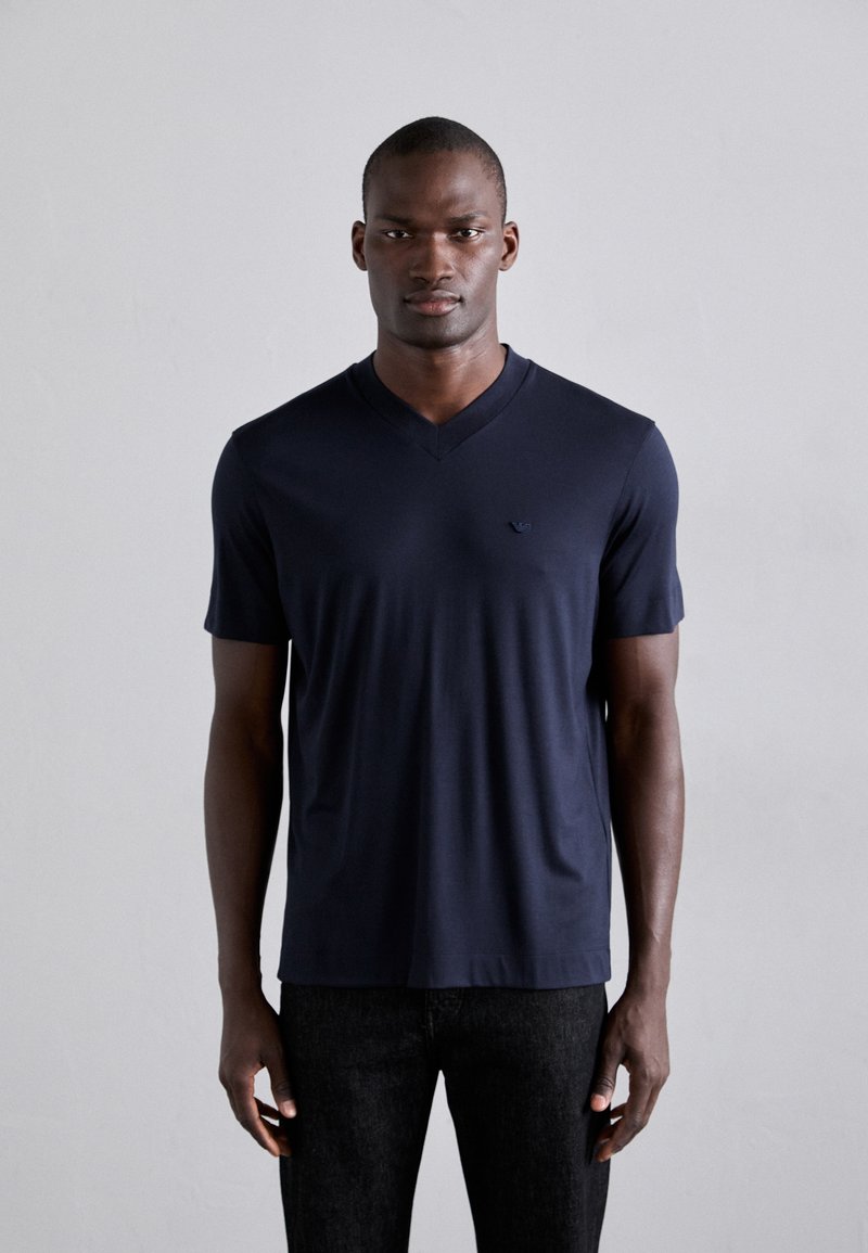Navy blue short-sleeve V-neck t-shirt in soft fabric with a fitted design and subtle logo accent on the left chest.