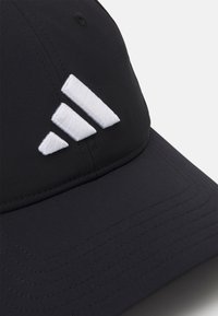 Fekete sapka ívelt nappal. Elülső részén három fehér hímzett csíkkal. Sima szövettextúra látható varrással.