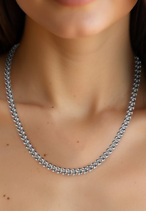 Silberne Kettenhalskette mit ineinandergreifenden ovalen Gliedern, mit einer glatten, polierten Oberfläche. Eng am Hals getragen, um das Design hervorzuheben.