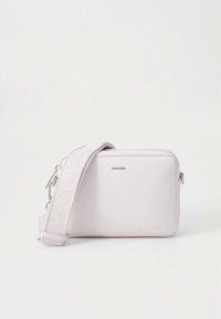Calvin Klein crossbody bag in soft pink, made of smooth synthetic material, featuring a logo strap, rectangular shape, and zip closure.